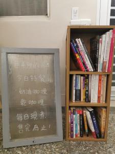 a chalkboard next to a book shelf with books at TOMO B&B in Taitung City