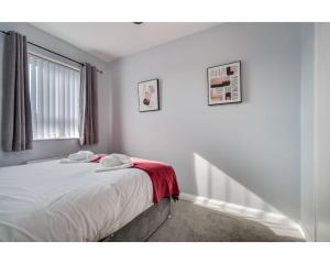 - une chambre avec un lit doté de draps blancs et une fenêtre dans l'établissement Central Belfast Apartments: Cromwell, à Belfast