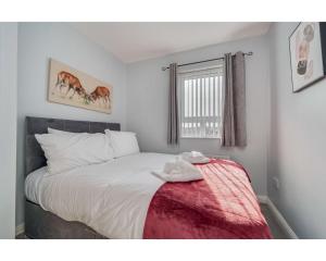 - une chambre avec un lit blanc et une couverture rouge dans l'établissement Central Belfast Apartments: Cromwell, à Belfast