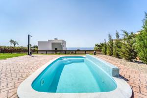 a swimming pool in the middle of a patio with a house at Heliophos Villa Amalthia in Kiotari