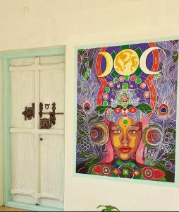 een schilderij van een vrouw aan een muur naast een deur bij Baba Luru's in Varkala