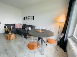 a living room with a table and chairs and a couch at Apartment Eerste Reeg für 2-4 Personen mit Pool in Dahme