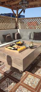 drewniany stół z jedzeniem na górze w obiekcie Dar Malika w mieście Al-Dżadida