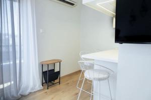 a room with a table and chairs and a television at Cozy Studio In The Heart of City in Komotini