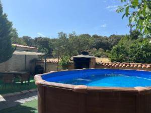 einen großen Pool im Garten mit Tisch und Stühlen in der Unterkunft Casa Rural El Medico in Serradilla del Arroyo