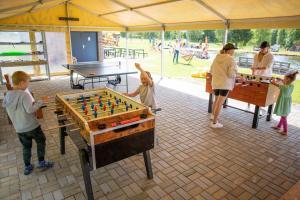 a group of children playing a game of billiard at Amenity Hotel & Resort Lipno in Lipno nad Vltavou