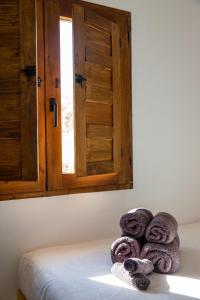 una pila de toallas sentadas en una cama con ventana en Atalaya, en Olías