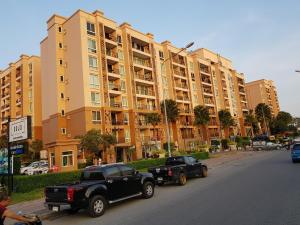 two trucks parked in front of a large building at Atlantis Condo Resort GP in Jomtien Beach