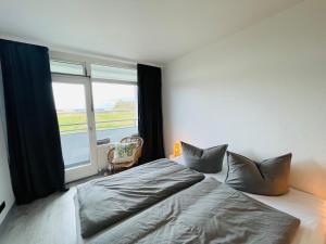 a bedroom with a bed and a large window at Apartment Eerste Reeg für 2-4 Personen mit Pool in Dahme