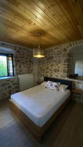 a bedroom with a large bed with a wooden ceiling at Six blossoms ! in Exanthia