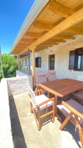 a wooden table and chairs under a wooden roof at Six blossoms ! in Exanthia