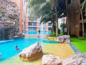 a pool in a hotel with people in the water at Atlantis Condo Resort GP in Jomtien Beach