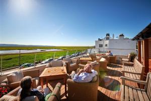 eine Gruppe von Personen, die auf einer Terrasse auf Stühlen sitzen in der Unterkunft The Ship in Parkgate