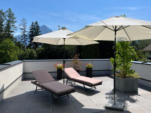 two chairs and two umbrellas on a patio at Wohlfühlapartments Steiner in Altmünster