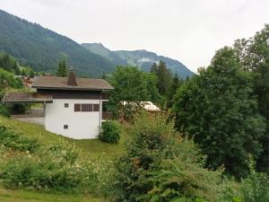 ein weißes Haus auf einem Hügel mit Bergen im Hintergrund in der Unterkunft Le Chardon Bleu in Châtel