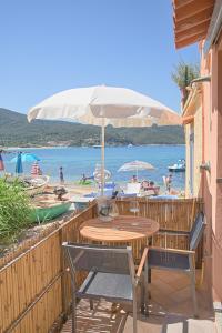 stół, krzesła, parasol i plaża w obiekcie Oyster Beach - Direttamente sulla Spiaggia del Forno w mieście Scaglieri