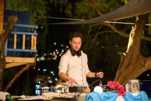 a man with a beard standing at a table at Lakki Village in Aegiali