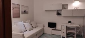 sala de estar con sofá blanco y escritorio en Caterina, en Castellabate