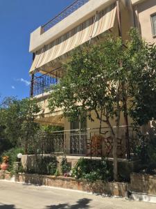 a building with a tree in front of it at Afrodite Hotel Apartments in Myrina