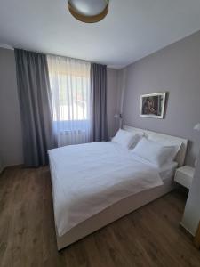 a bedroom with a large white bed with a window at Villa Maslina in Ljubuški +25 photos