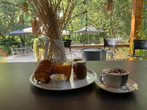 una mesa con dos platos de comida y una taza de café en Les Chalets de Labeaume, en Labeaume