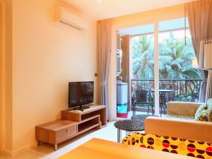 a living room with a television and a balcony at Atlantis Condo Resort GP in Jomtien Beach