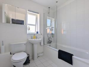 a white bathroom with a toilet and a sink at Saffron Court by Wycombe Apartments - Apt 08 in High Wycombe