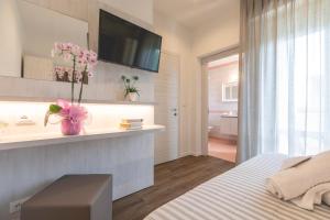 a bedroom with a bed and a bathroom with a sink at Hotel Loretta & Dependance in Cervia