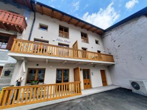 a large white building with a wooden balcony at Apartments Hlapi with SPA in Kobarid