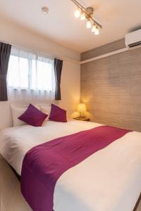 FDS AIM في أوساكا: غرفة نوم مع سرير أبيض كبير مع وسائد أرجوانية