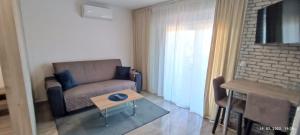 德拉葛的住宿－Apartmani Dalmacija Drage，客厅配有沙发和桌子