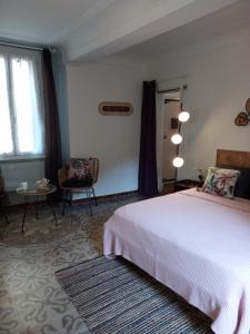 um quarto com uma cama, uma cadeira e uma janela em Côté cour em Lorgues