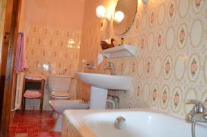 een badkamer met 2 toiletten, een wastafel en een bad bij Auberge du Lac in Bauduen