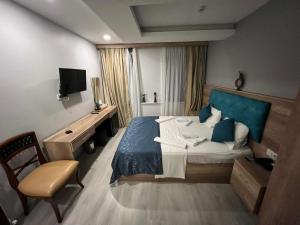 a bedroom with a bed and a chair and a television at Destinia Pera in Istanbul