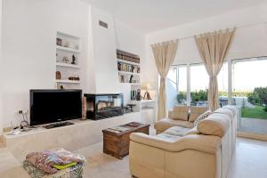 sala de estar con TV, sofá y chimenea en Apartamento Costa Zahara, en Zahara de los Atunes