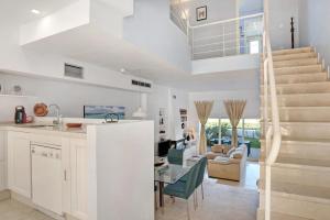 cocina y sala de estar con mesa y escalera en Apartamento Costa Zahara, en Zahara de los Atunes