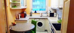 uma pequena cozinha com uma máquina de lavar roupa e uma mesa em Ferienwohnung Sille em Osnabrück
