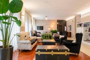 a living room with black furniture and a large plant at Hotel Globo in Formigine