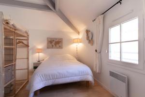 a white bedroom with a bed and a window at À 800m de la plage, maison pour 6 avec piscine in Plage-des-Demoiselles +15 photos