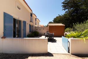 a patio with a table and a fence at À 800m de la plage, maison pour 6 avec piscine in Plage-des-Demoiselles