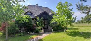 an old house with trees in the yard at Domek letniskowy Wczasy nad morzem in Sasino