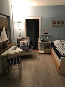 a bedroom with a bed and a desk and a chair at Ferienhaus Fehlhaber in Borkum