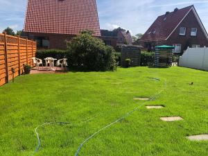 a yard with a hose laying on the grass at Ferienhaus Fehlhaber in Borkum
