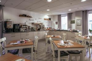 a restaurant with two tables and a kitchen at REGIOHOTEL Wolmirstedter Hof in Wolmirstedt