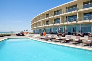 a hotel with a swimming pool next to a building at Lagoon Beach Apartment 309 in Cape Town