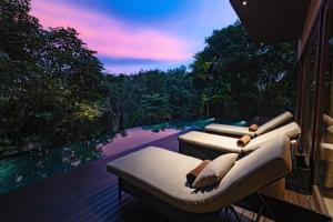 two couches on a deck with a view of a pool at Villa Lydia, Koh Yao Noi in Ko Yao Noi