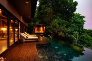 a house with a deck with a swimming pool at Villa Lydia, Koh Yao Noi in Ko Yao Noi