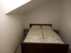 um quarto com uma cama com duas almofadas em Apartmani Dubrava 2 em Zagreb