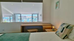 a bedroom with a bed and a window with a desk at Marina Algarve-CleverDetails, located on the marina close to all main amenities in Vilamoura +28 photos