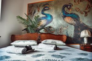 1 cama con 2 almohadas y una pintura en la pared en Villa Sequoia, en Leinì